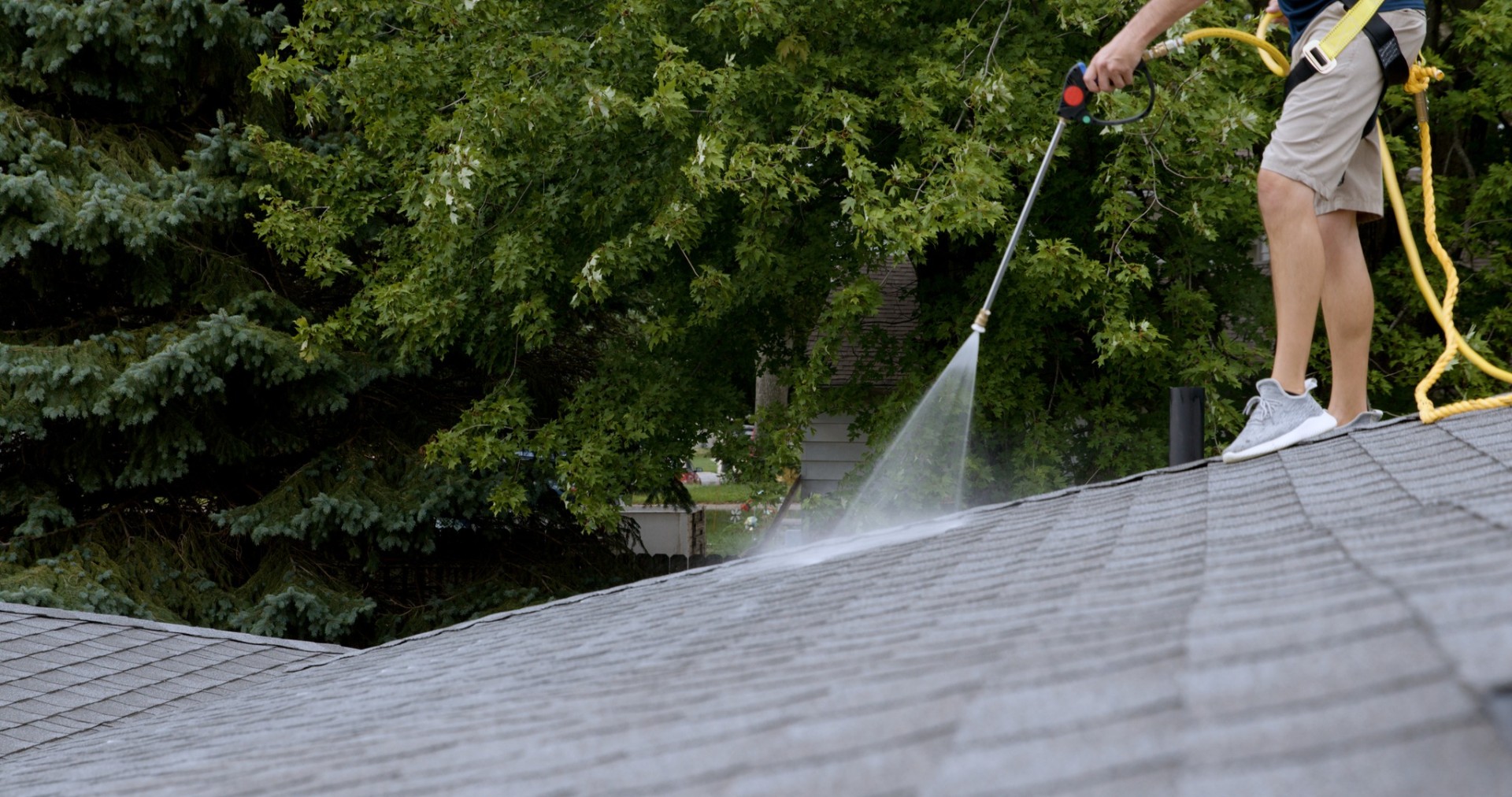 Shingle Savers technician applying roof treatment spray